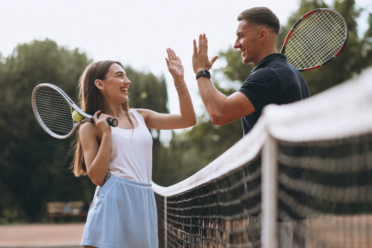 Pareja adulta jugando tenis en la cancha